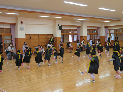 ホールで衣装を着て踊る子どもたちの写真