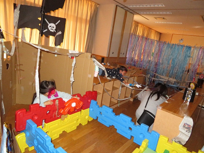 室内の段ボール迷路で子供たちが海賊ごっこをして遊んでいる写真