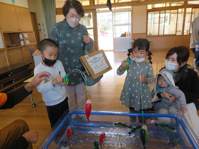 室内の水遊びコーナーで子供たちが魚つり遊びを楽しんでいる写真
