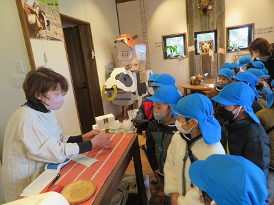 店内で園児が店員から商品を受け取っている写真