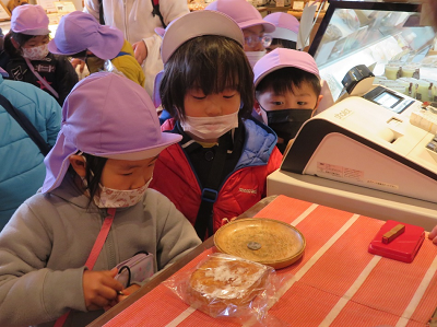 店内で園児が商品を購入している写真