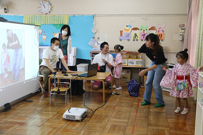 モニターに映し出されたおばけから女性に付き添われながら逃げるピンクの浴衣姿の女の子の写真