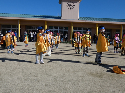 園庭で園児たちが列ごとにきれいに並び右手を前に出してポーズを決めている写真