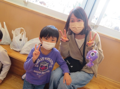 保護者の女性の方とピースサインを作って写真に映る男の子の写真