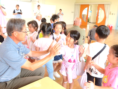 たくさんの園児たちが列になって並び、地域の方々と一人ずつハイタッチを交わしている写真