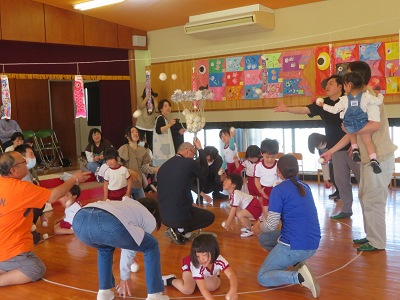 園児と保護者が一緒に白い玉入れを楽しんでいる写真