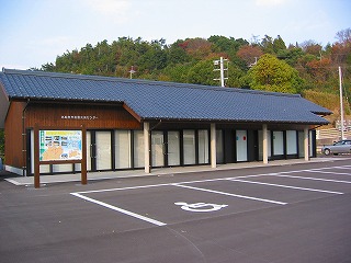 正面に多数のガラスの壁がある長い平屋の建物の写真