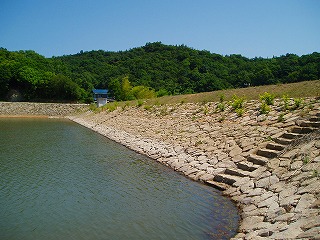 池を階段がある石積みの堤体で囲んだ写真