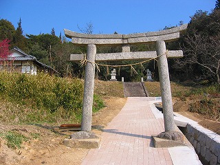 しめ縄が掛けられた鳥居の奥に神社の社殿が見える写真