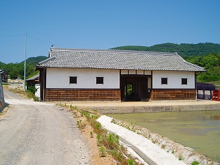 日本家屋の造りの瓦屋根と白い土壁が特徴的な長屋門の写真