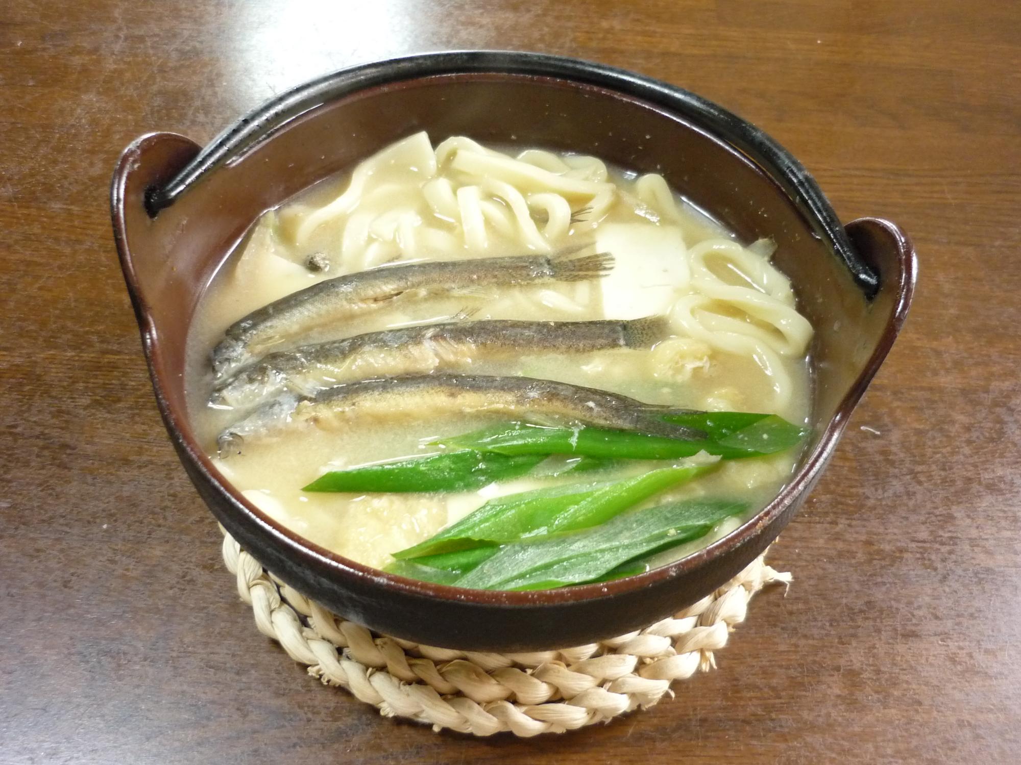 3匹の魚とネギが乗ったうどんの写真