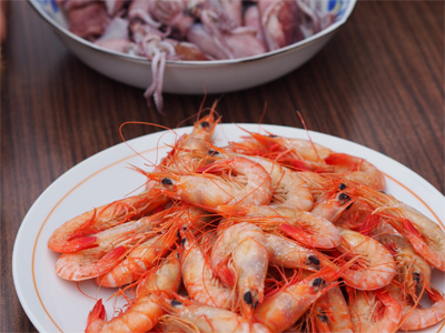 海老がたくさん乗った皿と烏賊がたくさん乗った皿が並べられている写真