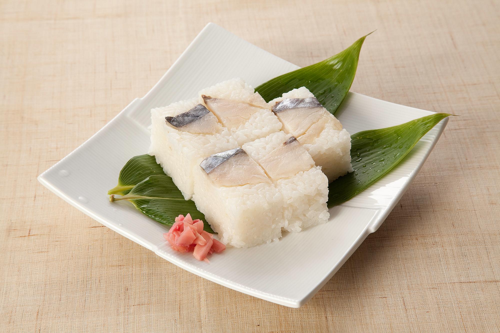 四角いお皿に乗った魚の押し寿司の写真