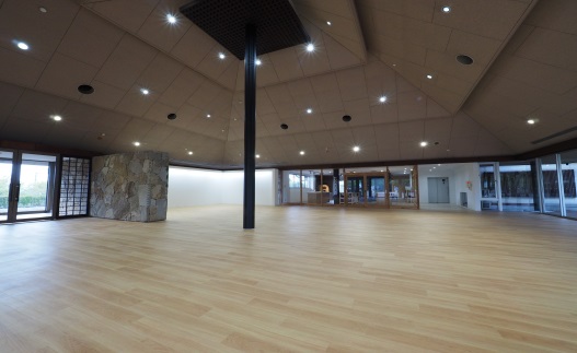 木のフローリングの広々としたホールの写真