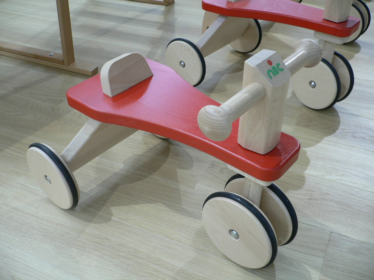 室内に置かれた木製三輪車の写真