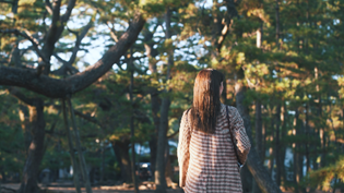 雑木林の中を進む女性の写真