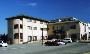 緑色の屋根の建物と駐車場の写真