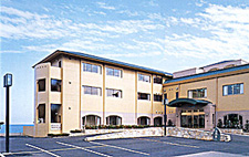 ベージュ色の壁で三階建ての建物を正面から撮影した写真