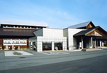 舗装された敷地に建てられた大きな三角屋根の建物の写真