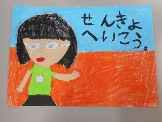 女の子の隣に「せんきょへいこう。」と書かれた絵の写真