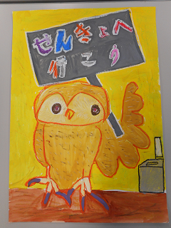 「せんきょへ行こう」と書かれた看板を持っている梟の絵の写真