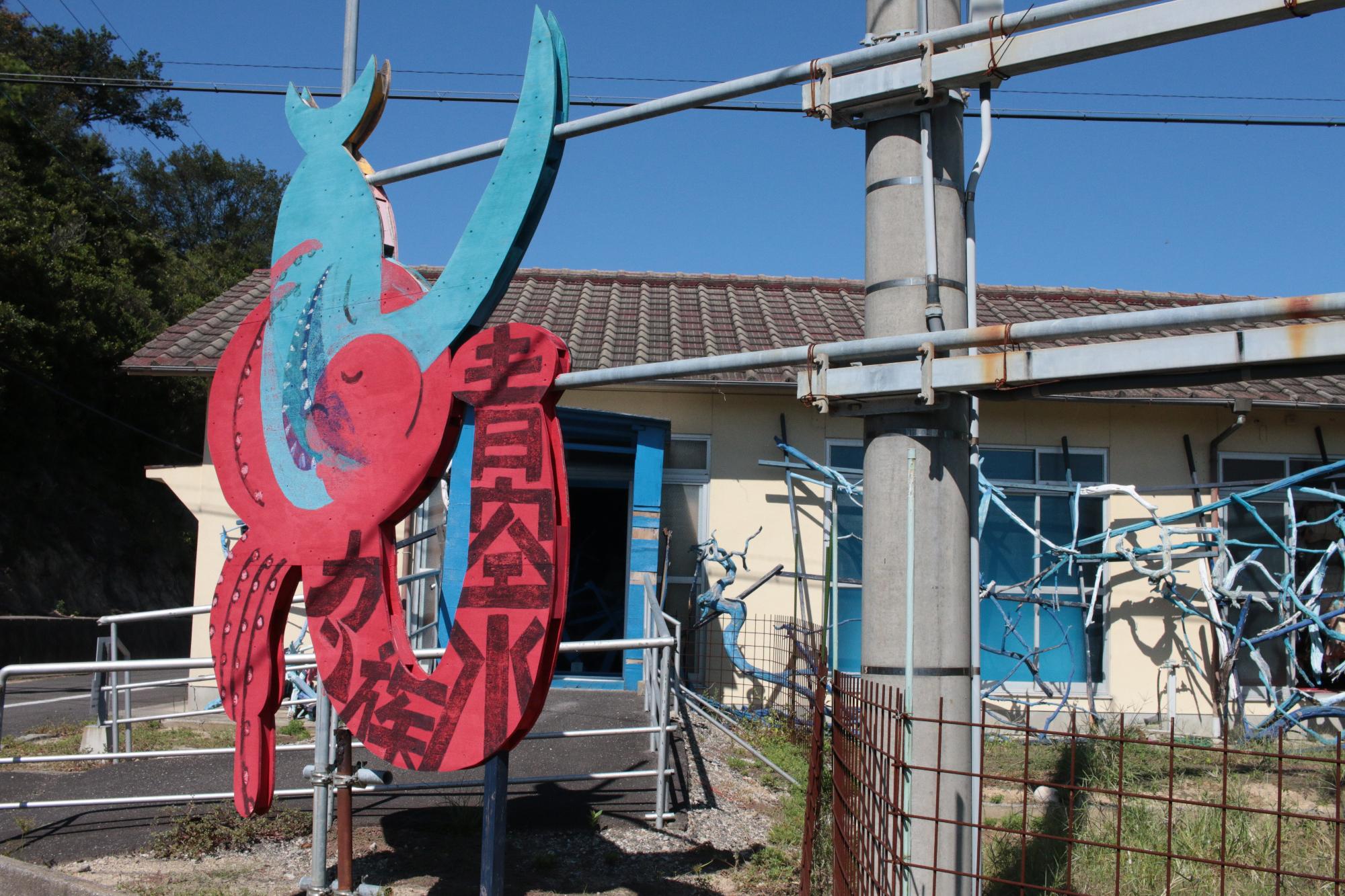 建物の外にイラスト看板が立っている写真