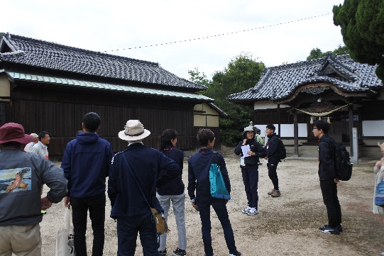 古民家の前でガイドの説明を聞く参加者たちの写真