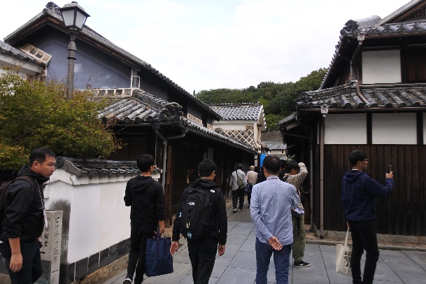 古い町並みの路地を散策する参加者たちの写真