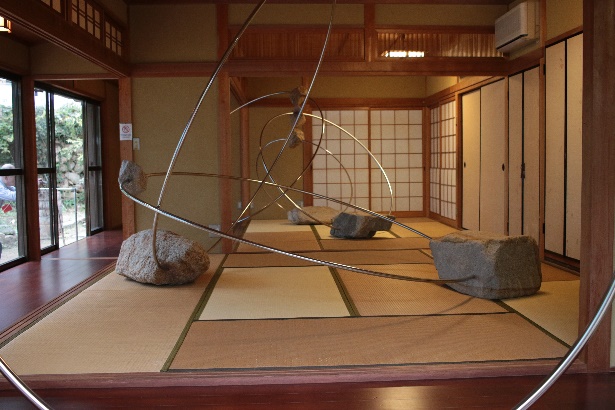 和室に展示された金属と石のアート作品の写真