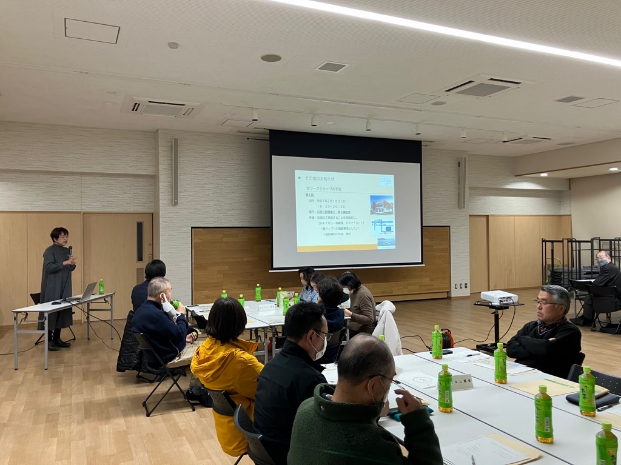 講師がスクリーンのスライドを使って説明している写真