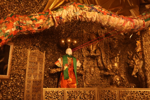 金色の空間に立つ人形作品のアート展示写真