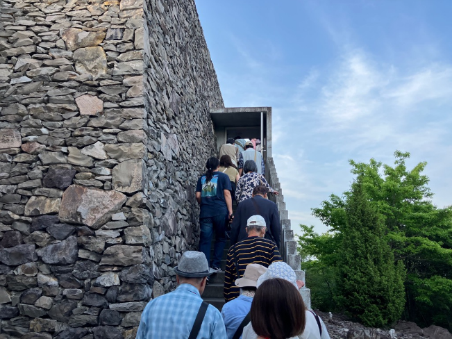 石造りの建物の外階段を列になって登る参加者たちの写真