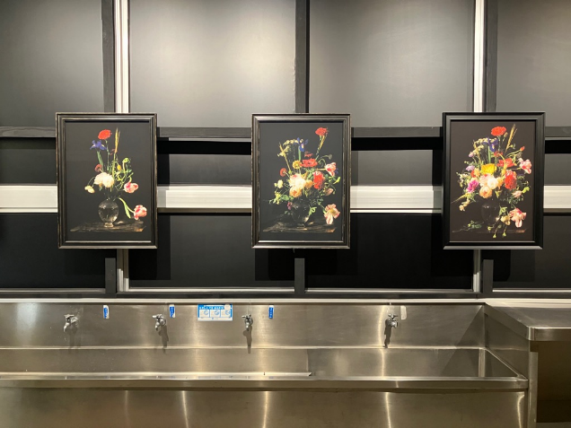 ステンレスの流し台の上に花の絵画が三枚並んで展示されている写真