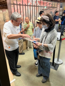 展示会場の入口で市長が来館者にパンフレットを示しながら説明している写真