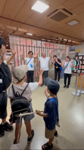 館内のロビーで子供たちとスタッフが向かい合って手を振り合いながら挨拶している写真