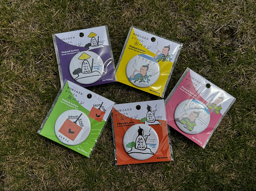 さぬき市デザイン缶バッジが芝生の上に並べられている写真