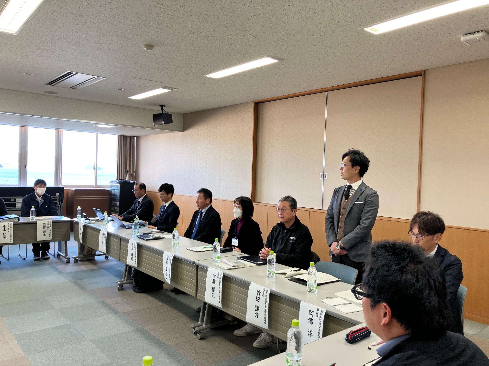 会議室で司会進行を行う男性の写真
