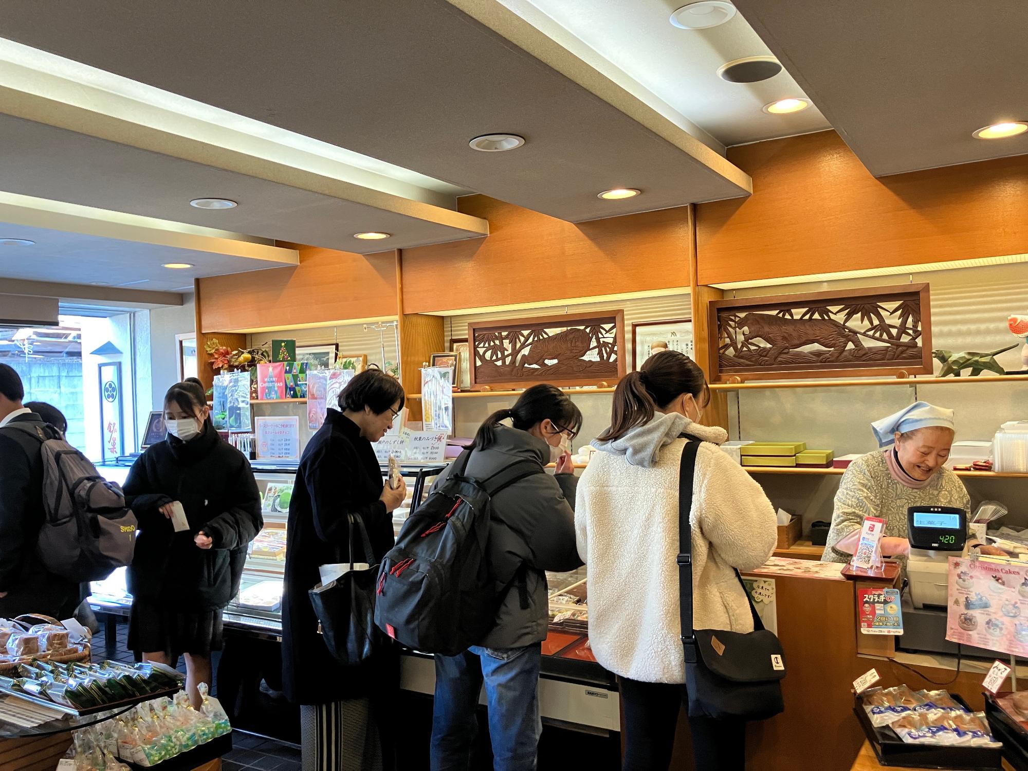 お菓子店で地域ならではの商品を購入する参加者の写真