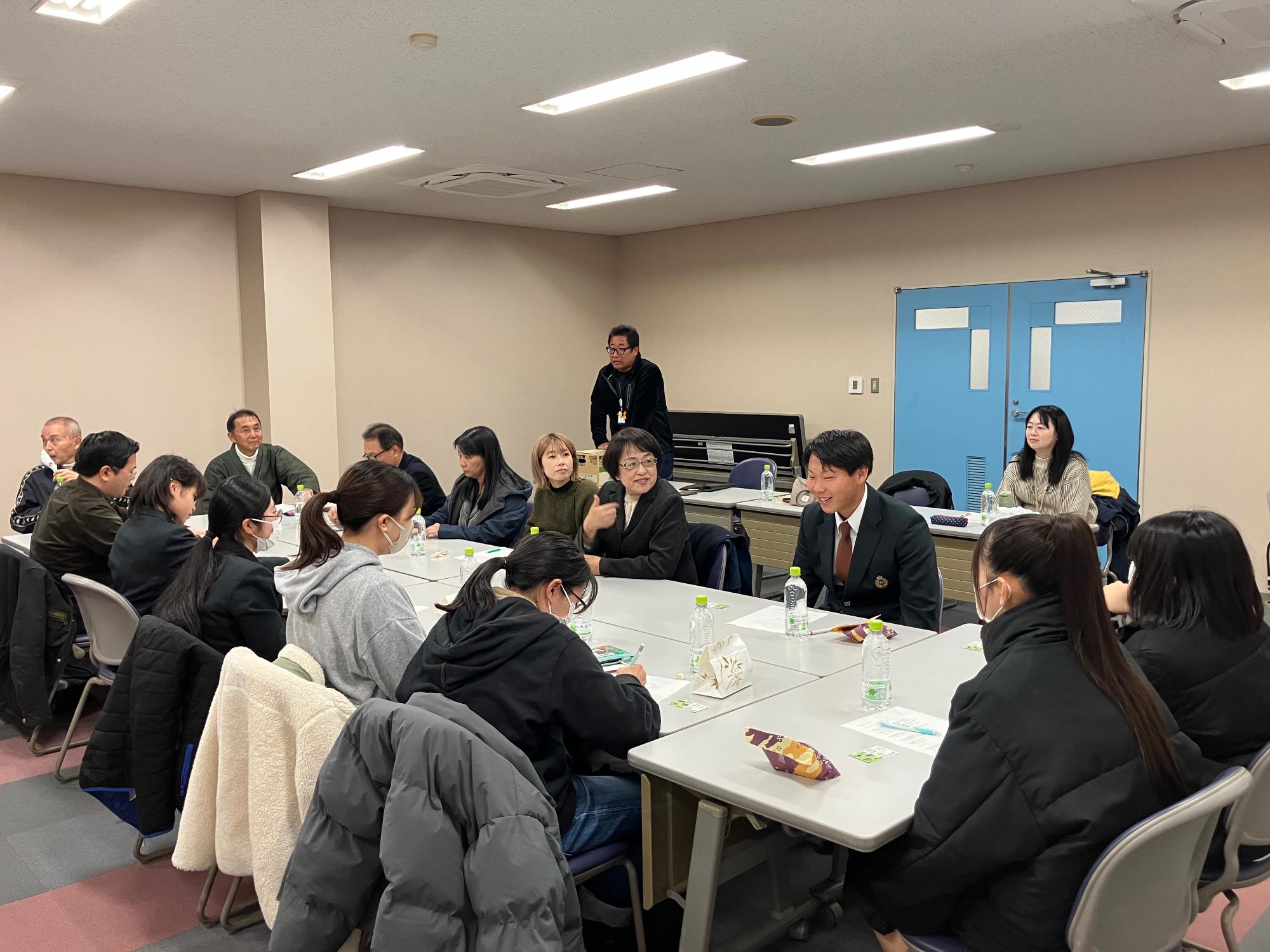 会議室にて意見を発表する参加者とその意見を聞く参加者の写真