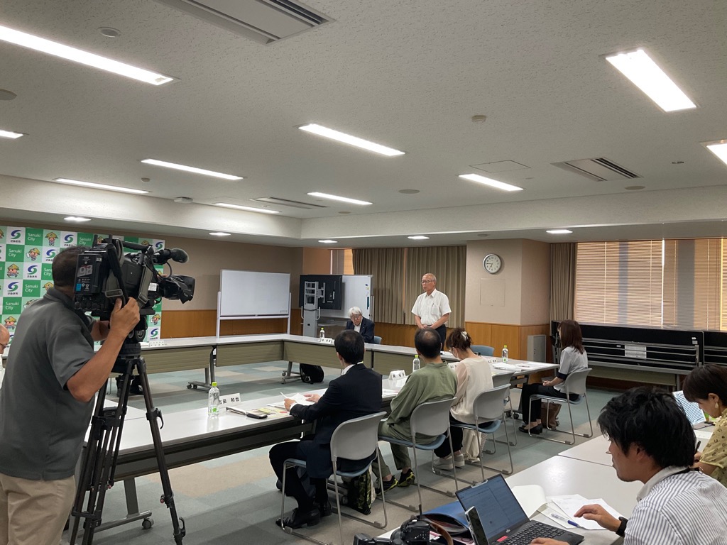 挨拶を行っている男性とそれを聞く参加者の写真