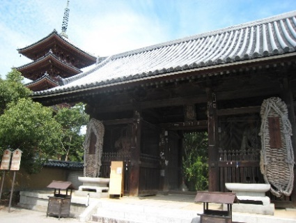 寺院の境内で大きな山門と背後の五重塔を写した写真