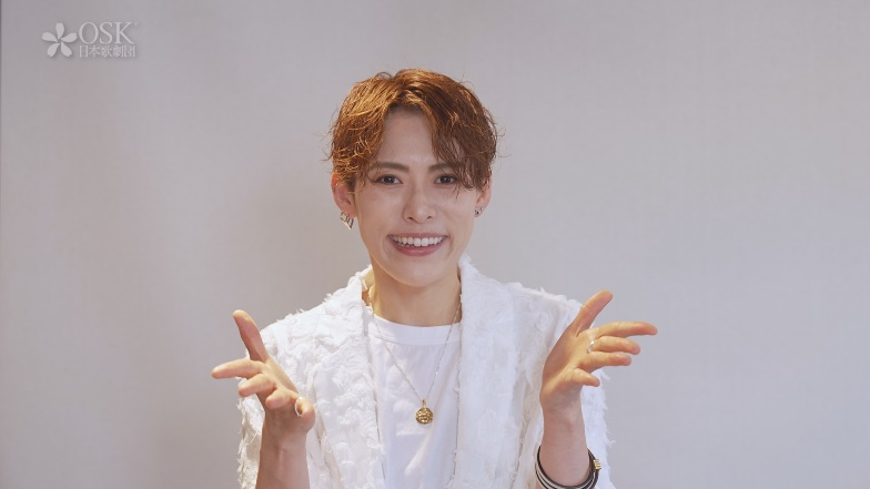 白い衣装で笑顔ポーズをとるOSK日本歌劇団スターのカジュアルショット写真