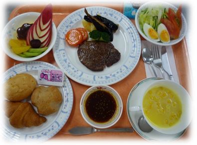 肉やパンが置かれたお皿がプレートに並べられている写真