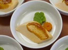 鮭の照り焼きにペースト状になったオレンジ色と緑色の具材が添えられている写真