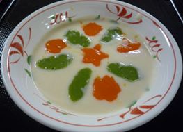 オレンジ色や緑色でペースト状になった具材が盛りつけられたシチューの写真