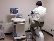 エアロバイクに乗る男性の後ろ姿の写真