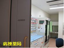 「病棟薬局」という文字とたくさんのネームタグが張られた棚のある部屋の入口の写真