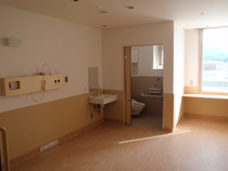 個室トイレ奥に設置されている下半分は茶色上半分は白の部屋の写真