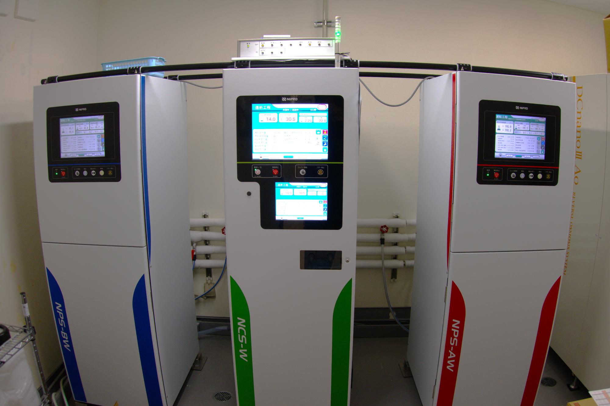 青、緑、赤で色分けされた3つの縦長の機械の写真