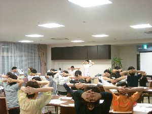 頭の後ろに手を回している人たちの写真